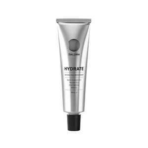 Eine silberne Tube mit der Aufschrift DALUMA FACIAL MOISTURIZER GESICHTSPFLEGE, mit natürlicher Feuchtigkeit aus Süßmandelöl, Sesamöl, Sheabutter und Neroli, steht aufrecht auf weißem Grund - für jeden Hauttyp geeignet.