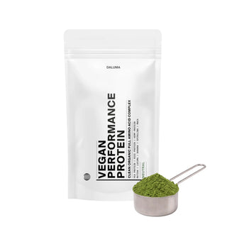 Ein weißer Beutel mit der Aufschrift DALUMA VEGANES PERFORMANCE PROTEIN NEUTRAL steht aufrecht neben einem Metallportionierer mit grünem Pulver. Die minimalistische Verpackung mit schwarzem Text auf weißem Grund hebt den neutralen Geschmack hervor.