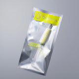 Eine DALUMA LONGEVITY GLOW MASKE – eine Peel-off-Gesichtsmaske für die Netzhaut in einem spritzenartigen Behälter, versiegelt in einem transparenten Plastikbeutel mit gelbem Logo.