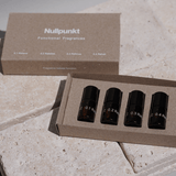Das NULLPUNKT DISCOVERY SET von Nullpunkt besteht aus vier kleinen Braunglasflaschen - 0.1 Relieve, 0.2 Release, 0.3 Refocus und 0.4 Refuel - in einer Markenbox, die auf einer hellen Steinoberfläche präsentiert wird.